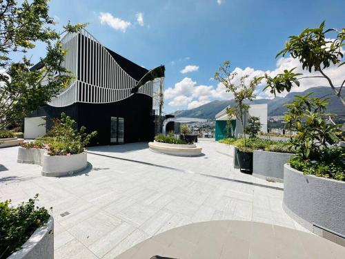 a courtyard with potted plants and a black building at La Carolina - Studio de lujo in Quito