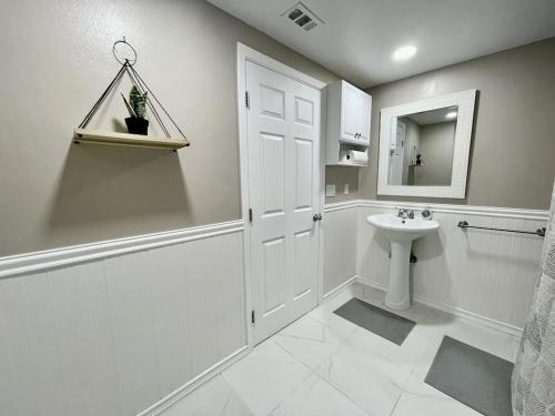 a white bathroom with a sink and a mirror at Central Location Family Size Home in Temple City