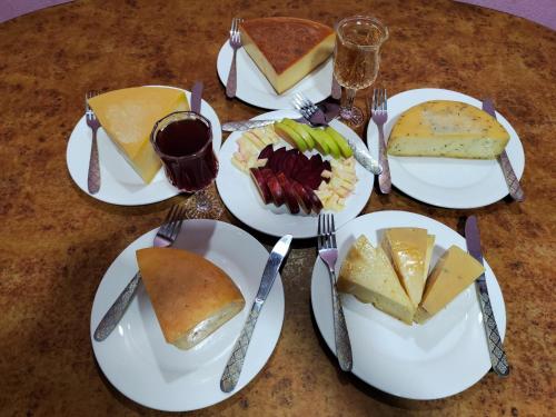 una mesa con platos de comida, tenedores y pasteles en Nepal Village Local Family Stay, en Bandipur