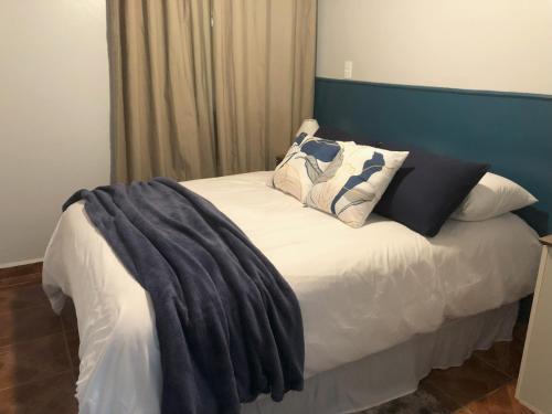 Una cama con almohadas y una manta. en Residência Vô José - Casa 02 en Pomerode