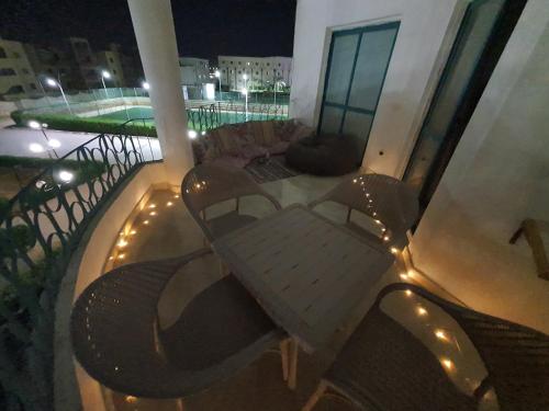 a table and chairs on a balcony with lights at Relaxed families sea view master bedroom in Raʼs Matarma