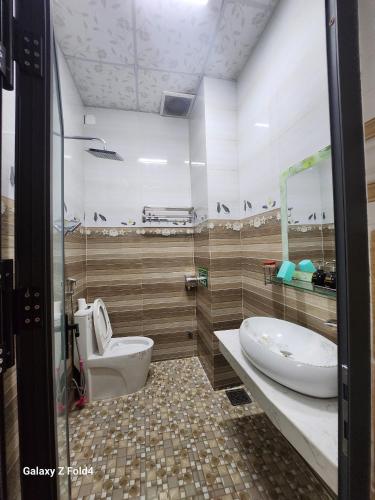 łazienka z toaletą, umywalką i wanną w obiekcie Vân Tân w mieście Kon Von Kla