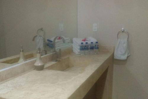 uma casa de banho com lavatório e garrafas de água em Villa Colibri Casa Vacacional alberca asador jardín 15 huéspedes em Temixco