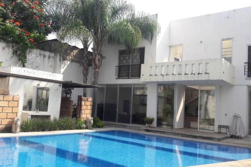 una piscina davanti a una casa di Villa Colibri Casa Vacacional alberca asador jardín 15 huéspedes a Temixco