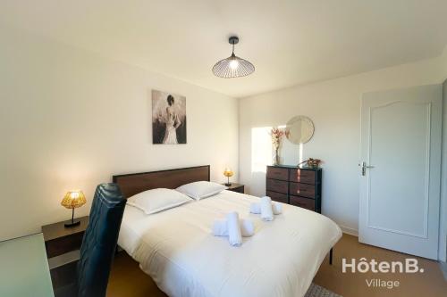 um quarto com uma cama grande, lençóis brancos e toalhas em Green Haven T2 with Large Garden em Panazol