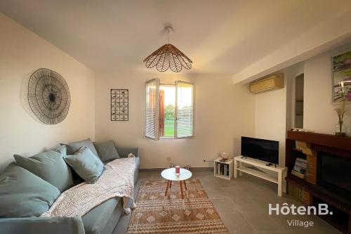 uma sala de estar com um sofá azul e uma televisão em Green Haven T2 with Large Garden em Panazol
