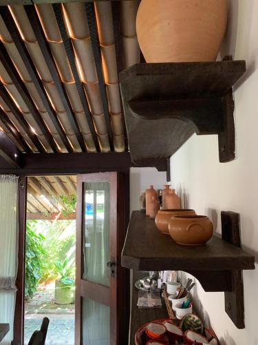 a kitchen with a wooden ceiling with a pot on a shelf at Linda Casa na Penha ! in Vera Cruz de Itaparica