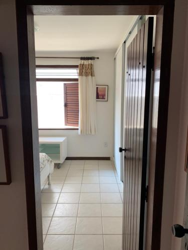 a room with a hallway with a window and a door at Linda Casa na Penha ! in Vera Cruz de Itaparica
