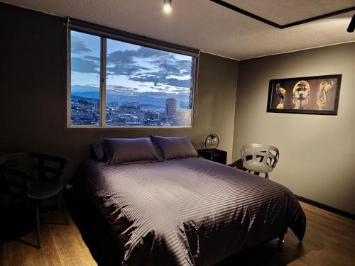 um quarto com uma cama e uma grande janela em Acogedor y Moderno Apartamento Centro Histórico em Bogotá