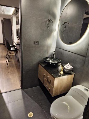 y baño con aseo, lavabo y espejo. en Acogedor y Moderno Apartamento Centro Histórico, en Bogotá