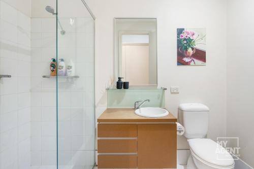 a bathroom with a toilet and a sink and a shower at Melbourne Bourke Street Bliss in Melbourne