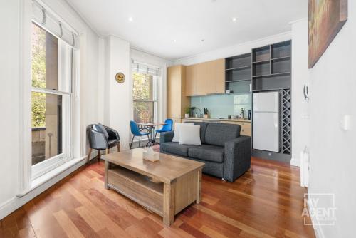 a living room with a couch and a table at Melbourne Bourke Street Bliss in Melbourne
