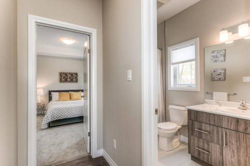 a bathroom with a sink and a bedroom with a bed at Riverside Villa in Kitchener