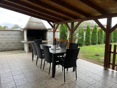 a table and chairs on a patio with an outdoor oven at ALOM in Osijek