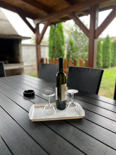 a bottle of wine sitting on a table with glasses at ALOM in Osijek