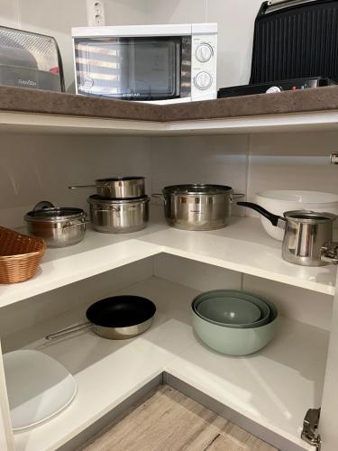 a kitchen with pots and pans on a shelf at ALOM in Osijek
