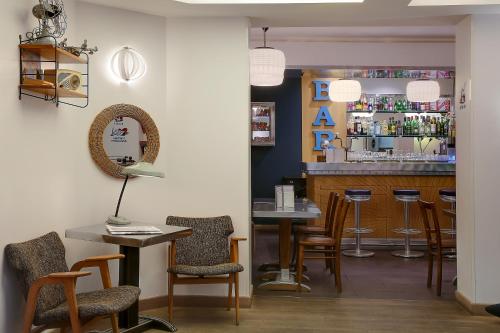 - un bar avec des chaises, une table et un comptoir dans l'établissement Hotel Aulivia Opéra, à Paris