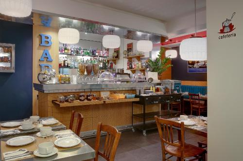 Un restaurante con mesas y sillas y un bar. en Hotel Aulivia Opéra, en París