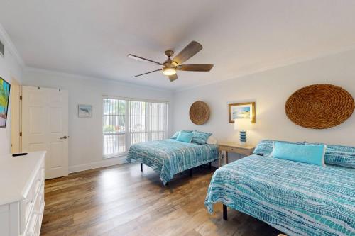 a bedroom with two beds and a ceiling fan at 247-B - Madeira Beach Yacht Club in St. Pete Beach