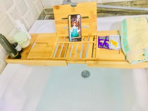 un vassoio di legno con un telefono cellulare in cima a un letto di Bảo Châu Garden a Buôn Dru Dak Mam