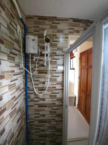 a bathroom with a brick wall at Betsy's Bed and Breakfast Moalboal in Moalboal