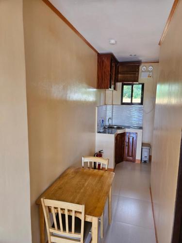 a small kitchen with a wooden table and chairs at Moalboal Cay in Moalboal