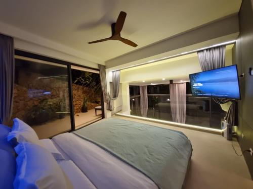 a bedroom with a bed and a flat screen tv at Magic suites Seaview villas, Koh Samui in Choeng Mon Beach