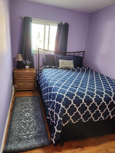 a bedroom with a blue and white bed with a window at Winnipeg Place to Stay in Winnipeg