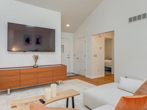 a living room with a couch and a tv on a wall at Upscale Home near Blossom, CVNP, Ski Resorts in Cuyahoga Falls