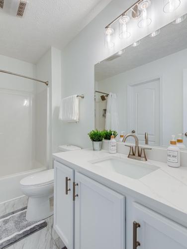 a white bathroom with a sink and a toilet at Upscale Home near Blossom, CVNP, Ski Resorts in Cuyahoga Falls