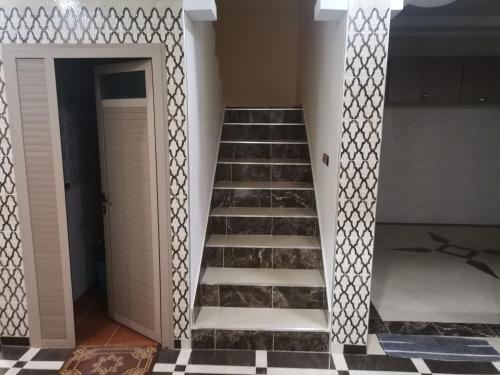 a staircase in a room with black and white tiles at Villa in Tamri Agadir in Agadir