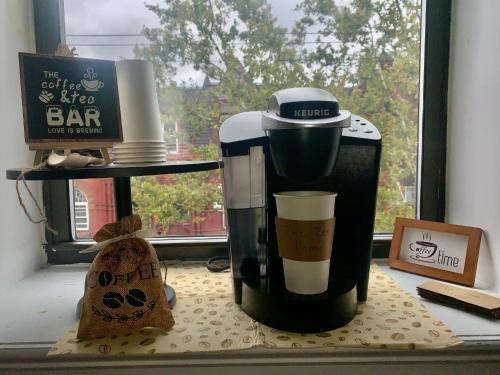 a coffee maker sitting on a table next to a window at The Zen Home near Temple U & Drexel FREE STREET PARKING in Philadelphia