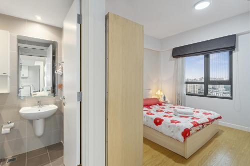a bedroom with a bed and a sink and a bathroom at Cozy 2 Bedrooms Condo in T1 Masteri Thao Dien, Fully Furnished With Full Amenities in Ho Chi Minh City