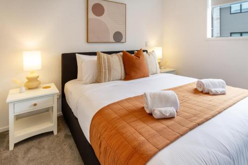 Duas camas num quarto com uma mesa de cabeceira e uma cama sidx sidx sidx em Gorgeous Getaway on Gloucester St- 1 Bed 1 Bath em Christchurch