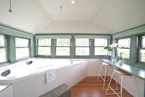 La salle de bains est pourvue d'une grande baignoire et de fenêtres. dans l'établissement 2 Bedroom Self Contained Apartment with Spa, à Ballarat