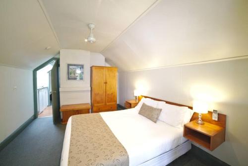 - une chambre avec un grand lit blanc et une fenêtre dans l'établissement 2 Bedroom Self Contained Apartment with Spa, à Ballarat