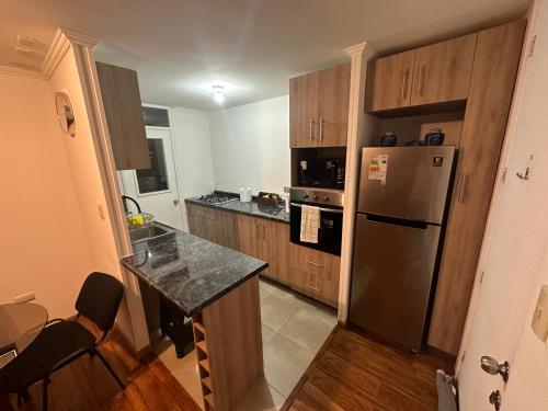 a kitchen with wooden cabinets and a stainless steel refrigerator at Apartamento punta Arenas in Punta Arenas