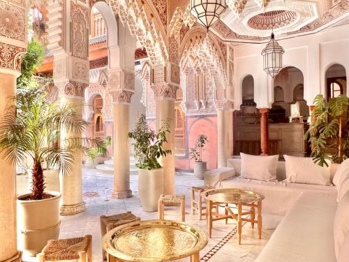 un soggiorno con divano e tavoli in un edificio di Riad Azad & Spa a Marrakech