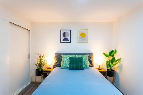una camera con un letto blu e due piante di Private bedroom in Roma Norte in Mexico City a Città del Messico