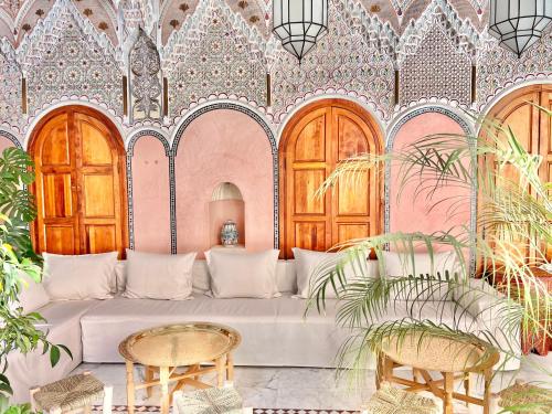 a living room with a white couch and a pink wall at Riad Azad & Spa in Marrakech