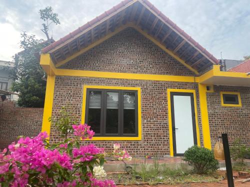 a small brick house with a yellow trim at Tam coc happy homestay in Ninh Binh