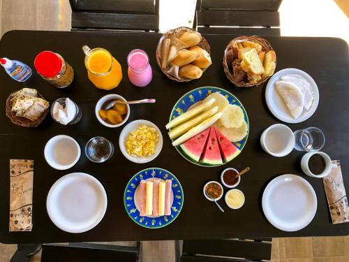 a black table with plates of food on it at Pousada Jardins - Mar Grande in Vera Cruz de Itaparica