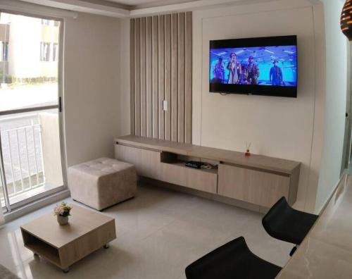 a living room with a flat screen tv on a wall at Encantador Apto Con Aire in Neiva