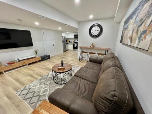 a living room with a couch and a clock on the wall at Vinash Luxury Suite in Edmonton