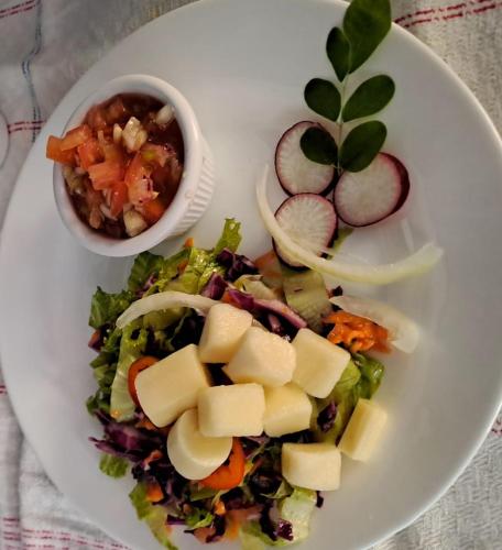 a white plate with a salad and a bowl of food at Vista Alta Ecolodge Bahia Drake in Drake
