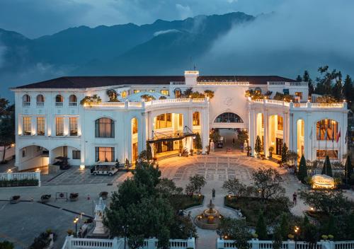 a large white building with a courtyard at night at Silk Path Grand Sapa Resort & Spa in Sa Pa