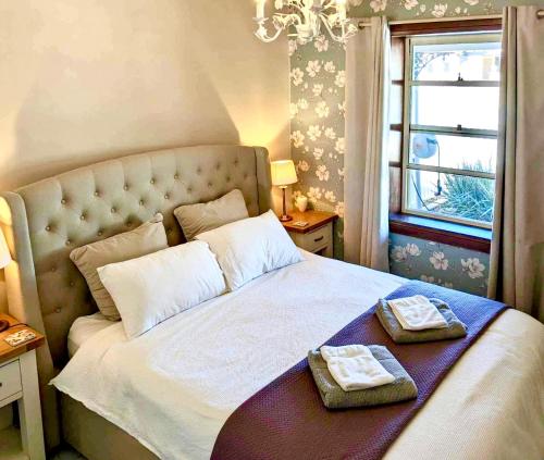 een slaapkamer met een bed met twee handdoeken erop bij Inglenook Cottage in Moonta