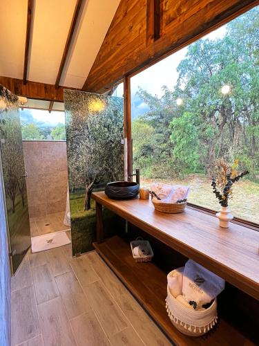 a bathroom with a large window and a wooden table at Hotel La Villa de Victoria Villa de Leyva in Sáchica