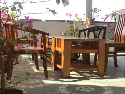 einen Holztisch und Stühle auf einer Terrasse in der Unterkunft New Way Hotel in Cát Bà