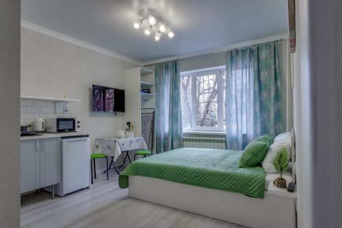 een kleine slaapkamer met een bed en een keuken bij Asaapart Mega Studio 2 in Alma-Ata